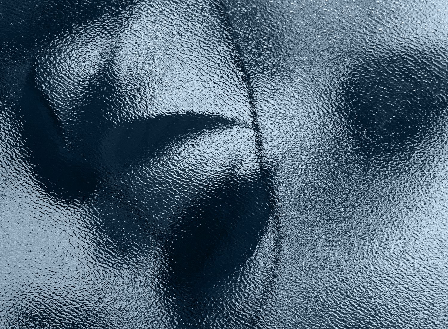 Abstract patterns on textured glass surface.