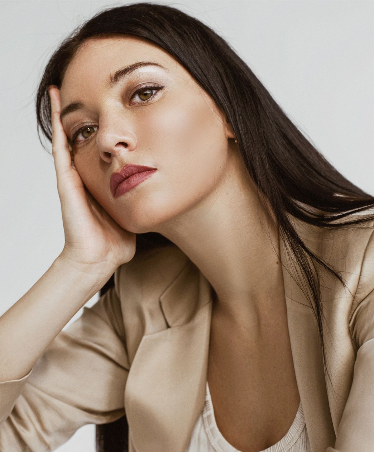Woman resting her head on hand thoughtfully.
