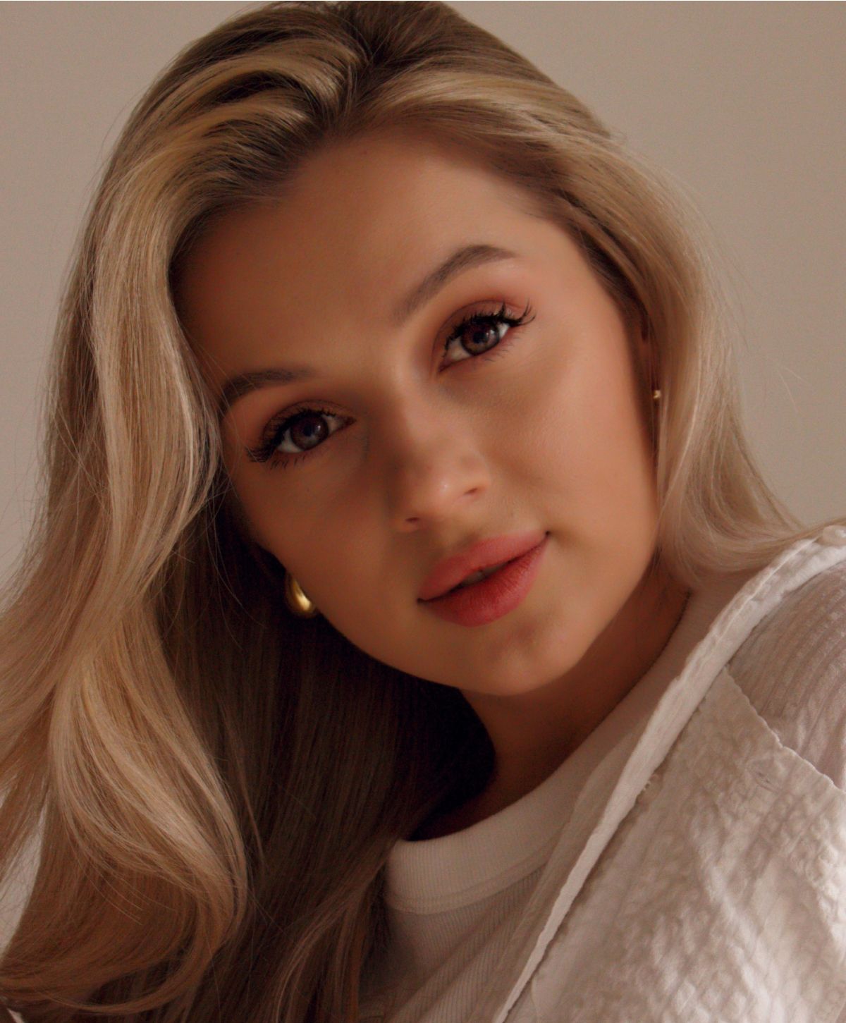 Woman with long blonde hair and natural makeup.