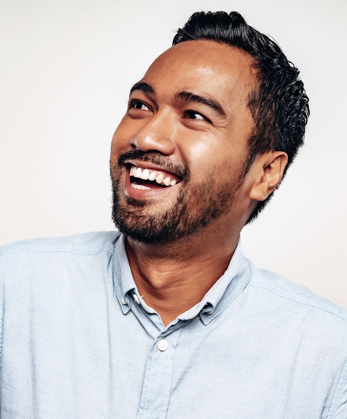 Smiling man with dark hair and beard.