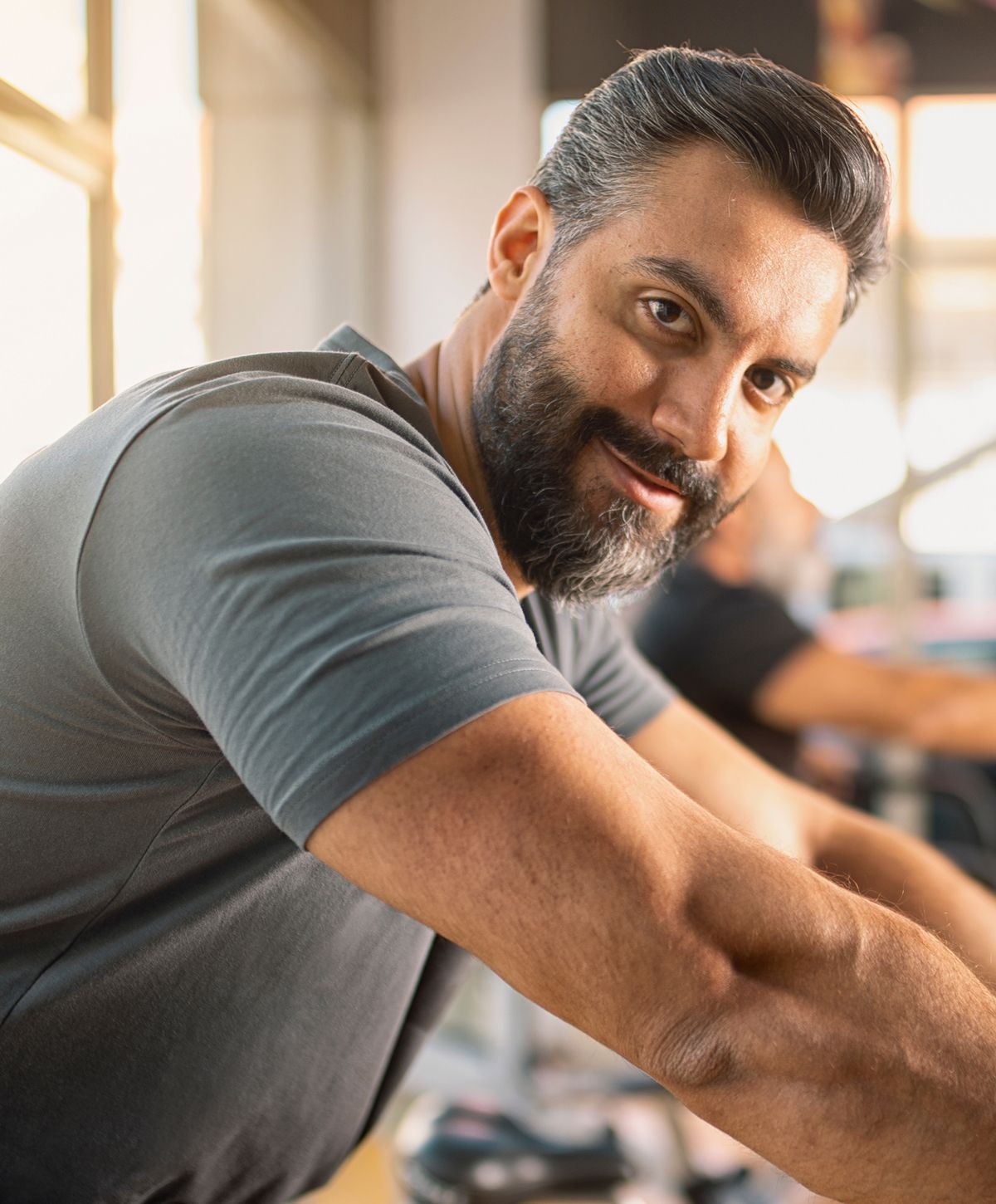 Man smiling at the gym, engaged in exercise.
