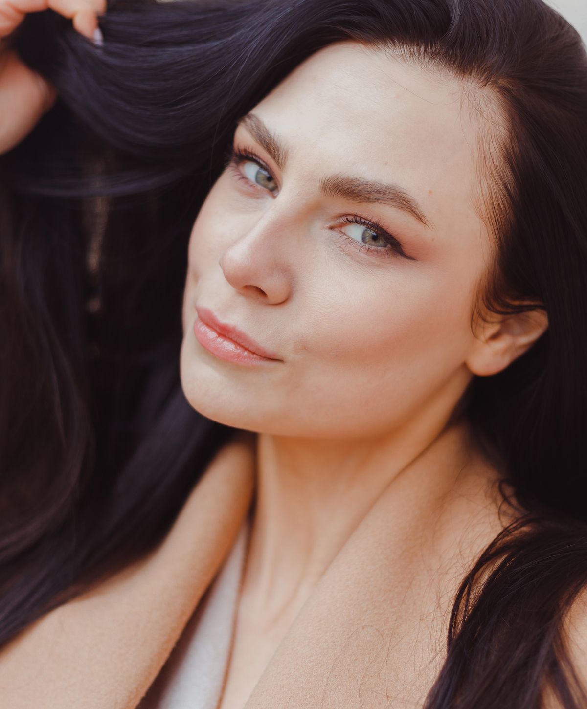 Woman with dark hair and a confident expression.