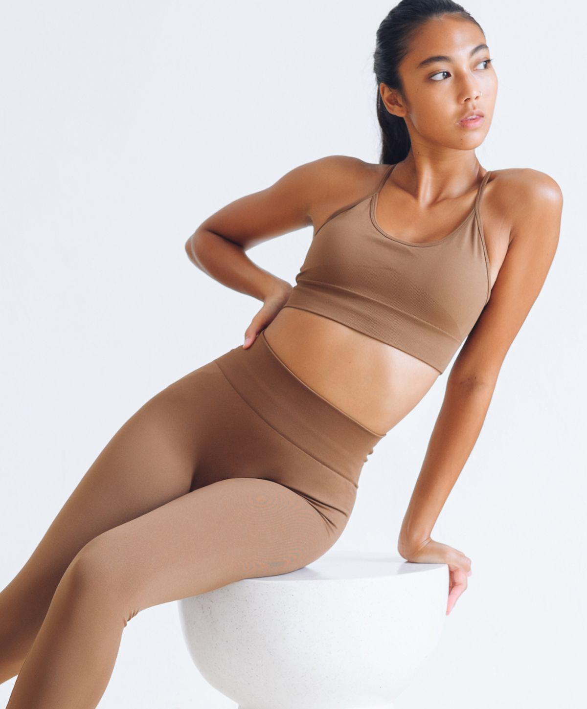 Model in brown athleisure wear posing confidently.