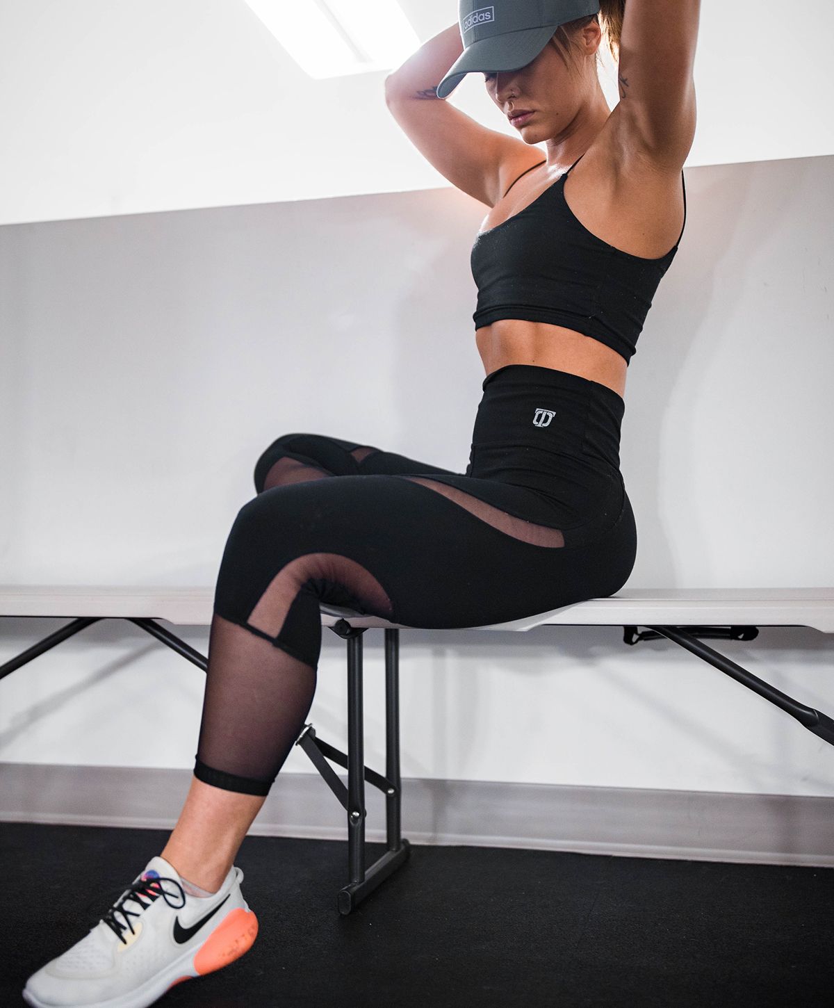 Woman in athletic wear sitting on a bench.