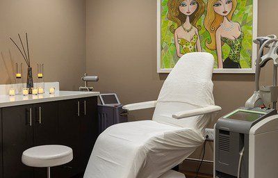 Cosmetic treatment room with a chair and equipment.