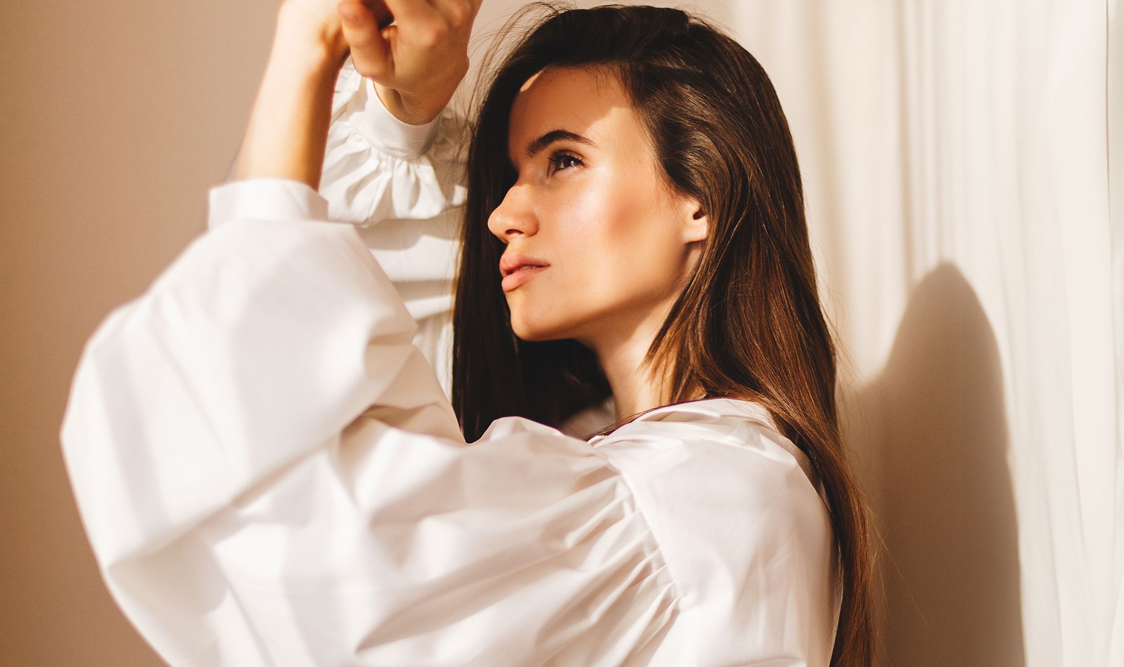 Woman in white blouse with soft lighting.