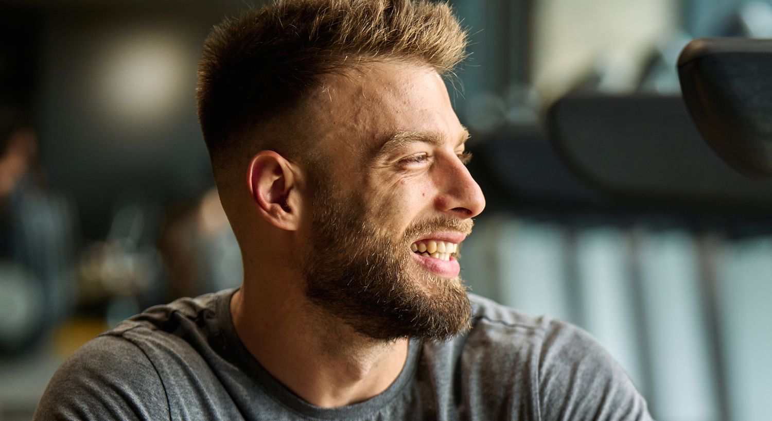 Smiling man with beard in casual setting.