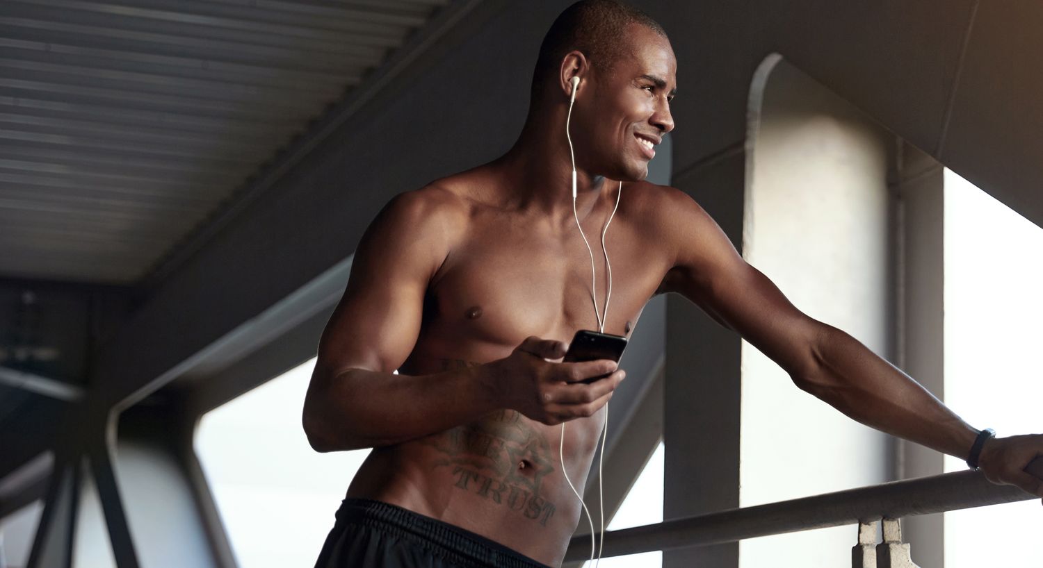 Man listening to music while leaning on railing.